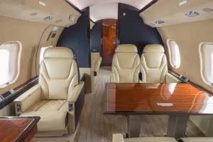 Global XRS forward cabin looking aft, featuring beige leather executive club seating and forward bulkhead monitor