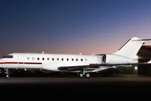 2007 Bombardier Global XRS exterior side view at night, Showing white fuselage with red stripe.