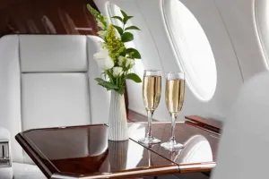 A close-up of the polished wood executive table in the Falcon 50EX cabin, highlighting the luxurious interior details